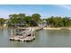 Waterfront home with private dock and beach access, set against a backdrop of lush greenery and clear blue skies at 2619 Buccaneer Rd, Isle of Palms, SC 29451