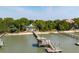 Picturesque waterfront home with private dock, sandy beach, and vibrant green trees under a clear blue sky at 2619 Buccaneer Rd, Isle of Palms, SC 29451