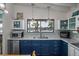 Bright kitchen with blue cabinets, stainless steel appliances, and tranquil water views at 2619 Buccaneer Rd, Isle of Palms, SC 29451