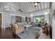Inviting living room showcasing comfortable seating, hardwood floors, and access to the outdoors through screened doors at 2619 Buccaneer Rd, Isle of Palms, SC 29451