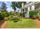 Beautiful backyard featuring lush greenery, trees, and steps to a screened porch at 27 Watroo Pt, Daniel Island, SC 29492
