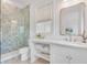 Bright bathroom features a sleek vanity with stylish gold fixtures and a glass-enclosed shower at 27 Watroo Pt, Daniel Island, SC 29492