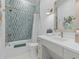Bathroom with green tile shower, white vanity and brushed gold fixtures at 27 Watroo Pt, Daniel Island, SC 29492