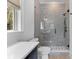 Bathroom showcasing tiled shower with glass door, white toilet, and grey vanity at 27 Watroo Pt, Daniel Island, SC 29492