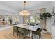 Elegant dining area features a decorative light fixture, large windows with a view, and comfortable seating for memorable meals at 27 Watroo Pt, Daniel Island, SC 29492