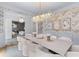 Elegant dining room with a large marble table, chandelier, and wainscoting at 27 Watroo Pt, Daniel Island, SC 29492