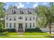 Charming two-story home features a landscaped yard, brick stairs, and inviting front entryway with traditional-style shutters at 27 Watroo Pt, Daniel Island, SC 29492