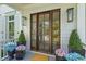 Charming entryway with a stained wood front door and potted plants at 27 Watroo Pt, Daniel Island, SC 29492