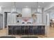 Bright, open kitchen with a large marble island, modern pendant lighting, and white cabinetry provides a sleek and stylish aesthetic at 27 Watroo Pt, Daniel Island, SC 29492
