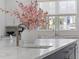 Kitchen island featuring white marble countertops, stainless faucet, and fresh flower arrangement at 27 Watroo Pt, Daniel Island, SC 29492