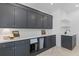 Laundry room with dark gray cabinetry, quartz countertops, lamp and sink at 27 Watroo Pt, Daniel Island, SC 29492