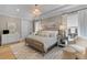Elegant bedroom with textured wallpaper, tray ceiling, and decorative light fixture at 27 Watroo Pt, Daniel Island, SC 29492