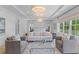Spacious and bright main bedroom featuring a seating area, tray ceiling, and large windows with a backyard view at 27 Watroo Pt, Daniel Island, SC 29492