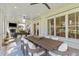 Covered outdoor patio with dining area, fireplace, and comfortable seating at 27 Watroo Pt, Daniel Island, SC 29492