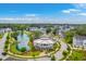 Aerial view of community clubhouse, pond, and golf cart path amidst lush greenery and well-maintained streets at 2710 Mcfadden Way, Johns Island, SC 29455