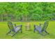 Landscaped backyard features a fire pit, Adirondack chairs, and a black metal fence for outdoor enjoyment at 2710 Mcfadden Way, Johns Island, SC 29455
