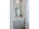 Well-lit half bath with a gray vanity, brushed gold mirror, and a decorative white orchid centerpiece at 2710 Mcfadden Way, Johns Island, SC 29455