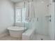 Bright bathroom with a soaking tub next to a window and glass-enclosed shower with white subway tiles at 2710 Mcfadden Way, Johns Island, SC 29455