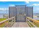 Gated entrance to a waterfront community with a wooden walkway leading to a secure, locked iron gate at 2710 Mcfadden Way, Johns Island, SC 29455