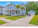 Charming two-story home with light blue siding, a manicured lawn, palm trees, and a long driveway at 2710 Mcfadden Way, Johns Island, SC 29455