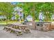 Community grilling area with picnic tables, a brick grill and lush green trees nearby at 2710 Mcfadden Way, Johns Island, SC 29455