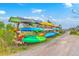 Outdoor kayak storage rack featuring a variety of colorful kayaks near a marsh trail under a sunny sky at 2710 Mcfadden Way, Johns Island, SC 29455