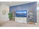 Living room features a sleek TV, gold shelving, and a modern blue textured wall for a unique design at 2710 Mcfadden Way, Johns Island, SC 29455