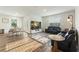Well-lit living room with hardwood floors, black leather seating, and an adjacent dining area at 286 W Bradford Pointe Dr, Summerville, SC 29486