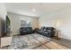 Bright living room with black leather furniture, patterned rug, and hardwood floors at 286 W Bradford Pointe Dr, Summerville, SC 29486