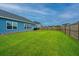 Large backyard with healthy green grass and a wooden fence for privacy, ideal for recreation at 302 Fiddleback Dr, Summerville, SC 29486