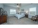 Spacious bedroom with a comfortable bed, ceiling fan, dresser, area chair, and ample natural light at 302 Fiddleback Dr, Summerville, SC 29486