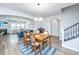 This dining room features an elegant chandelier, an archway, and transitions into a living room and stairway at 302 Fiddleback Dr, Summerville, SC 29486