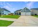 Charming home showcasing a two-car garage, manicured lawn, and blue siding at 302 Fiddleback Dr, Summerville, SC 29486