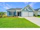 Charming home showcasing a two-car garage, manicured lawn, and beautiful blue siding at 302 Fiddleback Dr, Summerville, SC 29486