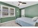 Bright bedroom featuring a large window, ceiling fan, and a tranquil green accent wall at 303 Gippy Dr, Summerville, SC 29486