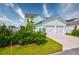 View of the home's two-car garage, landscaping, and well-manicured lawn offering convenience and curb appeal at 312 Clearpath Dr, Summerville, SC 29486