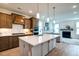 Open-concept kitchen featuring stainless steel appliances, a large center island, seamlessly connecting to the living room with a fireplace at 312 Clearpath Dr, Summerville, SC 29486