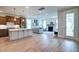 Open-concept kitchen with stainless appliances, island, and seamless flow to the living room with fireplace and outdoor access at 312 Clearpath Dr, Summerville, SC 29486