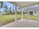 A covered back porch with white pillars overlooks the expansive and grassy backyard at 3214 Pinewood Dr, Ladson, SC 29456