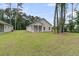 Spacious backyard featuring a well-maintained lawn and a covered patio, perfect for outdoor gatherings at 3214 Pinewood Dr, Ladson, SC 29456