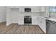 Stylish kitchen features stainless steel appliances, quartz countertops and shaker-style white cabinets at 3214 Pinewood Dr, Ladson, SC 29456