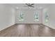 Bright living room featuring luxury vinyl flooring, two windows, a ceiling fan, and a glass door at 3214 Pinewood Dr, Ladson, SC 29456