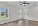 Bright living room featuring luxury vinyl flooring, two windows, a ceiling fan, and a glass door at 3214 Pinewood Dr, Ladson, SC 29456