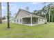 Rear view of home featuring a covered patio, windows, and lush lawn at 3218 Pinewood Dr, Ladson, SC 29456