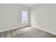 A clean, carpeted bedroom with neutral walls and a window allowing natural light at 3218 Pinewood Dr, Ladson, SC 29456