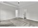 A large bedroom with light gray walls, trim and carpet is accented with doors leading to other rooms at 3218 Pinewood Dr, Ladson, SC 29456