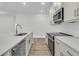 Bright modern kitchen with stainless appliances, island sink, quartz countertops, and light wood-look floors at 3218 Pinewood Dr, Ladson, SC 29456