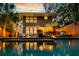 A tranquil backyard with a pool, spa, and outdoor seating, illuminated by soft exterior lighting at 340 President St, Charleston, SC 29403