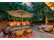 Backyard oasis featuring a fire pit, lounge furniture, dining table, and outdoor lighting at 340 President St, Charleston, SC 29403
