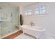 Elegant bathroom featuring a soaking tub and marble shower with glass surround at 340 President St, Charleston, SC 29403